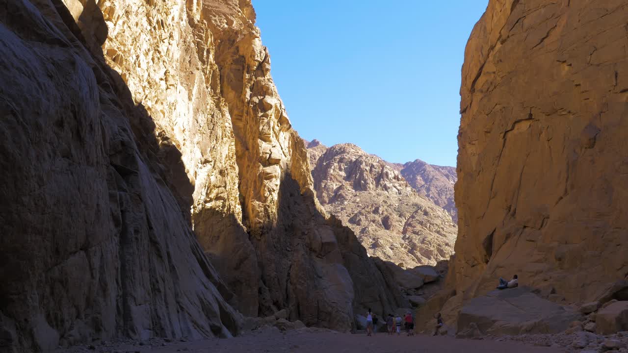 People hiking at Colored Canyon of Egypt Sinai desert Dahab in sunny day, wide shot
