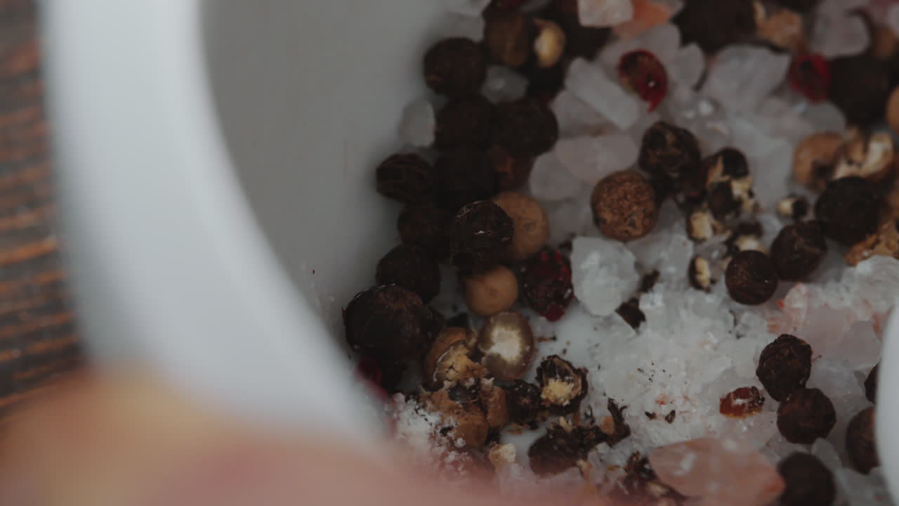 moliendo granos de pimienta y sal con mortero y pestillo