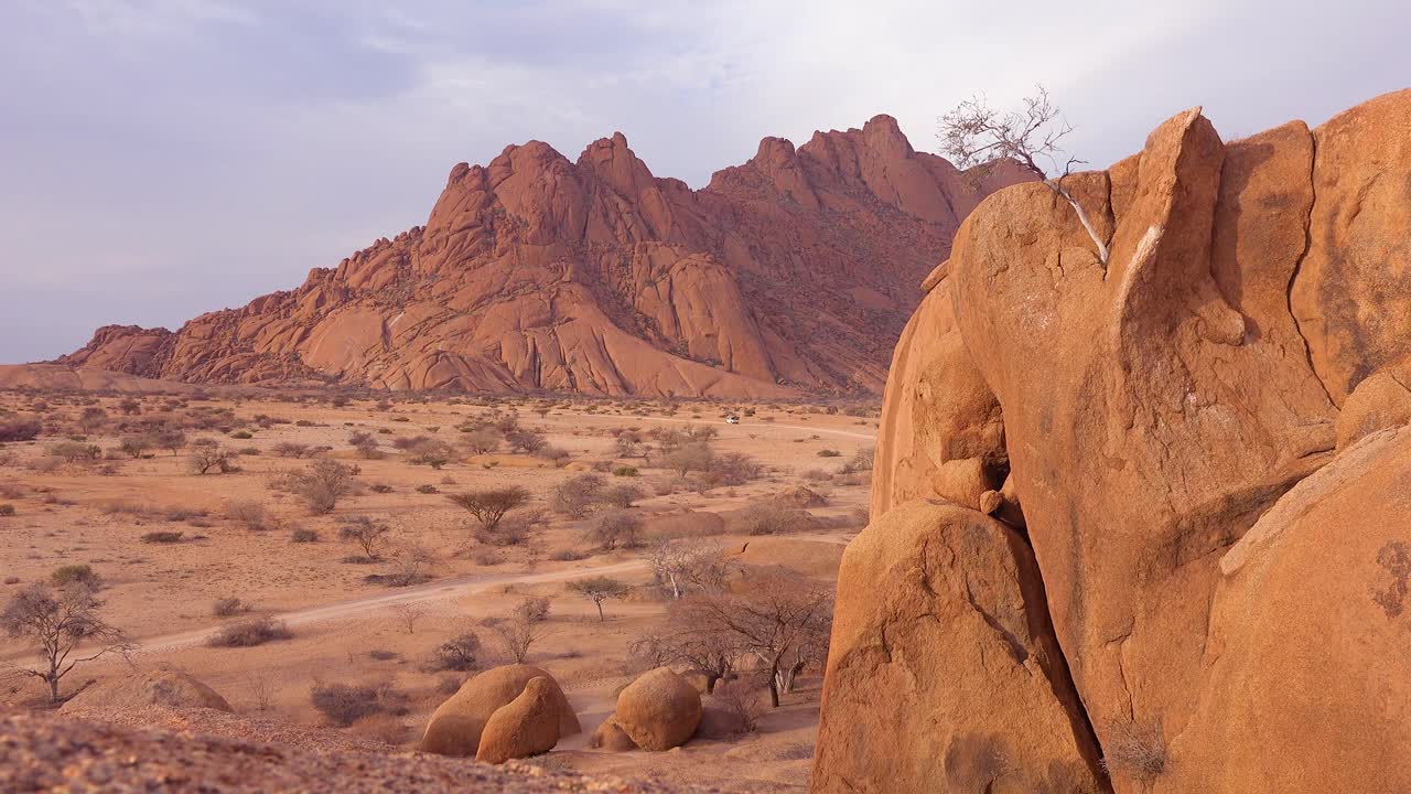 enormes formaciones rocosas y vehículos de safari distantes en spitzkoppe namibia