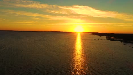 Aerial photo from flying drone of a fascinating nature landscape with dramatic evening sunset sky which reflected in sea water with calm waves. Beautiful scenery with sunset