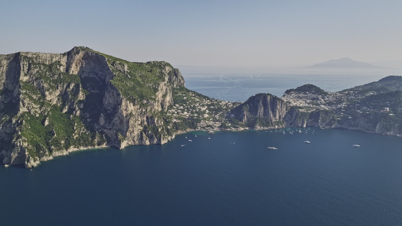 이탈리아 카프리 에어리얼 v2 고고도 드론은 해안 암석 형성과 티레네 해 위의 거친 절벽 리조트 마을의 멋진 풍경을  ⁇ 처했습니다. mavic 3 cine로 촬영되었습니다. 2023년 5월