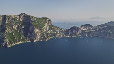 capri italy aerial v2 high altitude drone captured spectacular landscape views of coastal rock formations and a rugged cliffside resort town over the tyrrhenian sea - shot with mavic 3 cine - may 2023