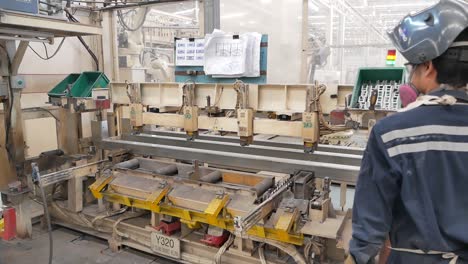 factory workers welding metal beams on an assembly line