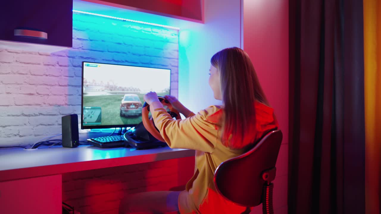 Nervous woman playing a video game. Girl sitting in front of the computer and playing with disappointment. Racing with a steering wheel at home. Gaming at home.