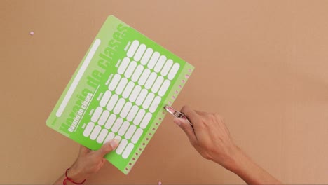 punching holes in school schedule planner with professional tool, paper arts and crafts