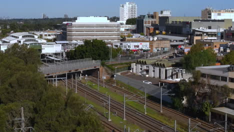toma aérea de las carreteras australianas en un suburbio ocupado con mucho tráfico ferroviario y automóviles y negocios - blacktown nsw pt 2