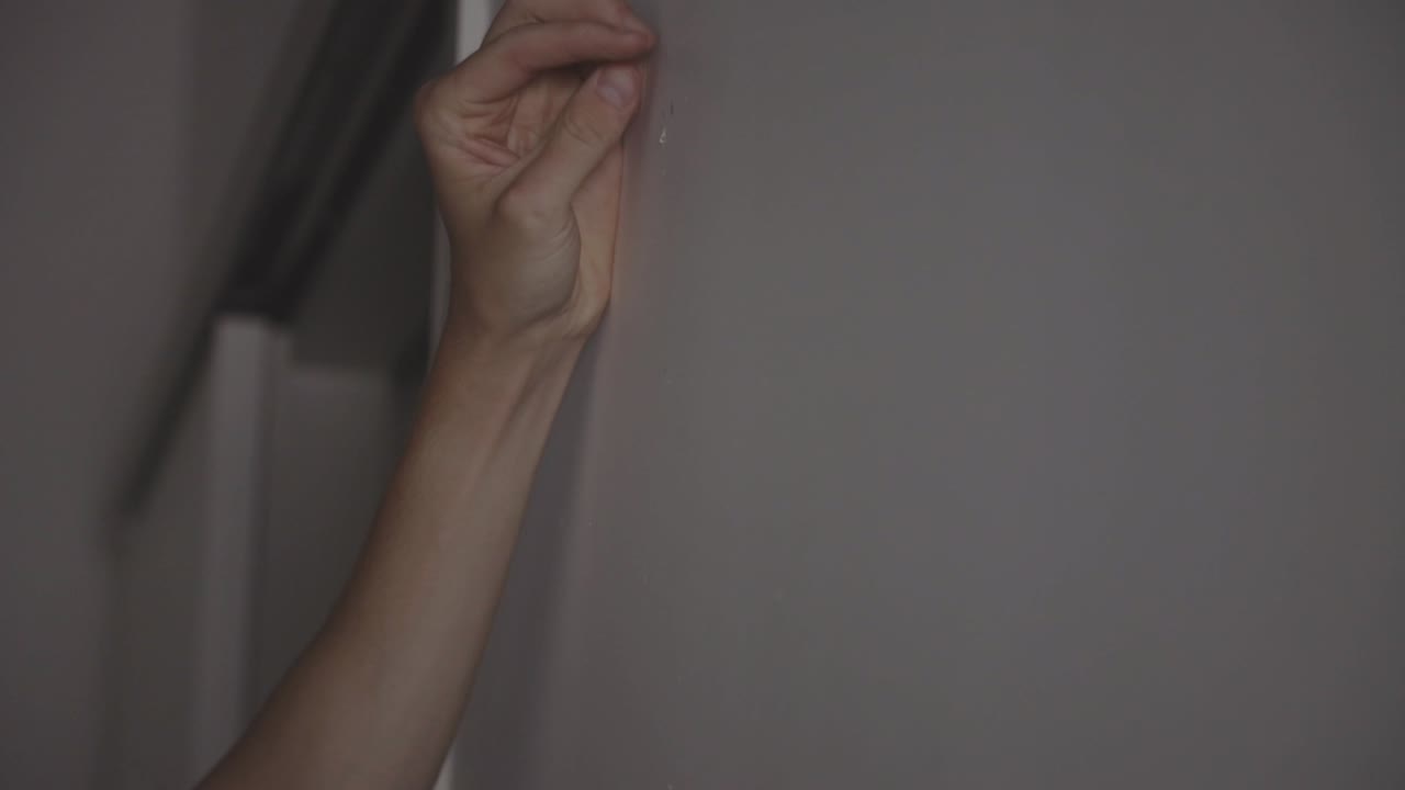 manos del hombre usando la máquina de perforación en la pared blanca - de cerca