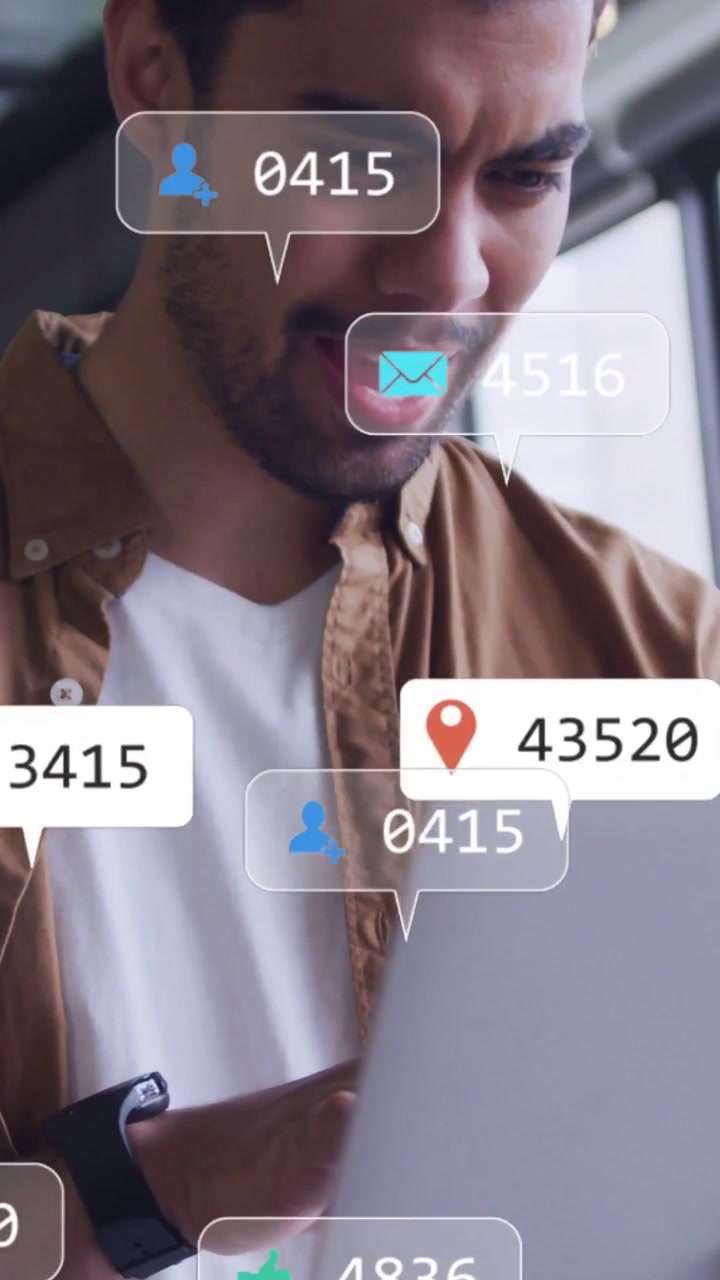 Vertical video: Man typing on laptop making social media icons and counts moving, tracking growth