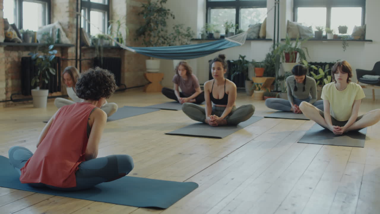 Girls Doing Butterfly Stretch on Group Yoga Class