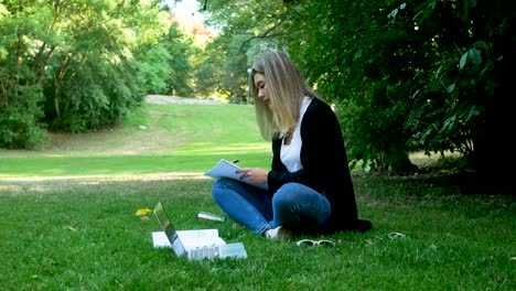 una chica estudiando en un parque.