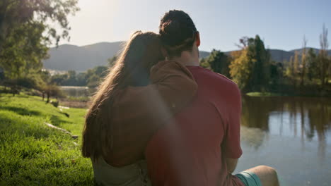 espalda, abrazo y pareja en un lago con para acampar
