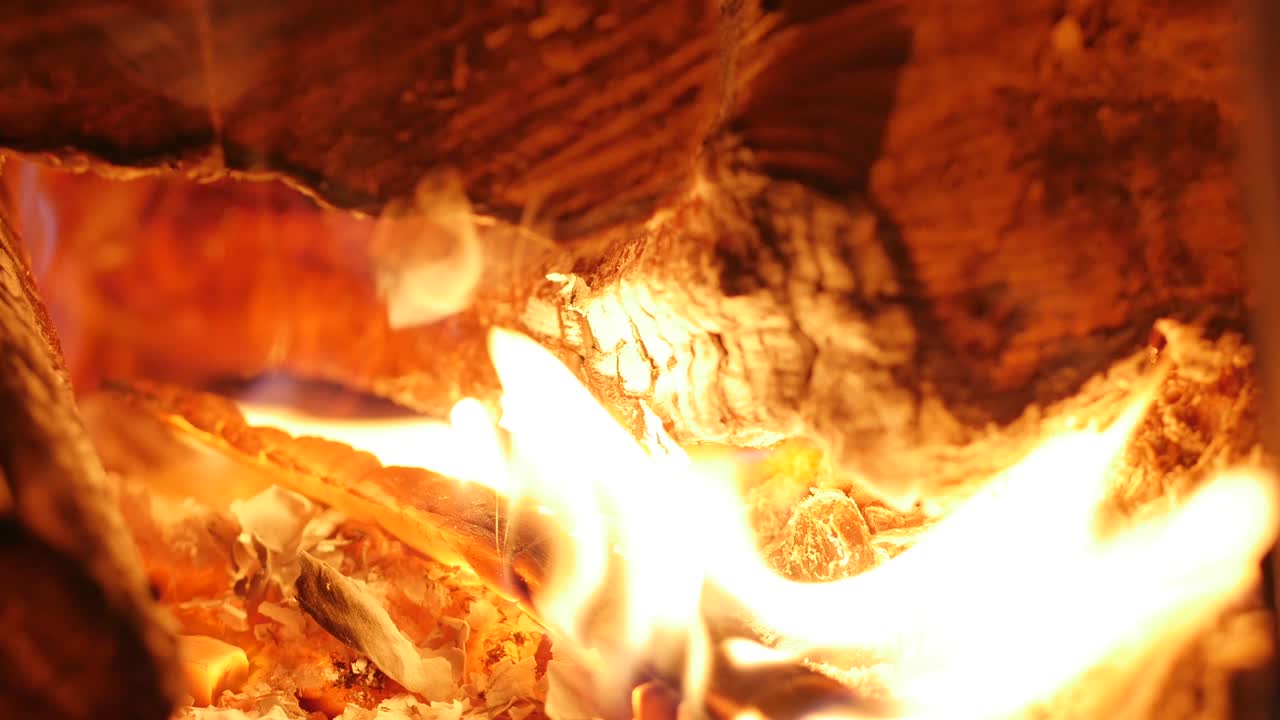 나무는 벽난로에서 아름답게 불타고, 남자의 손은 스토브에 연료를 넣고, 벽난로는 불을 태우고, 4k, 중간 불꽃 벽난라 루프 클램프.