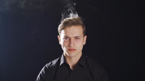 frustrated young man is angry and smoke is coming out of his head.