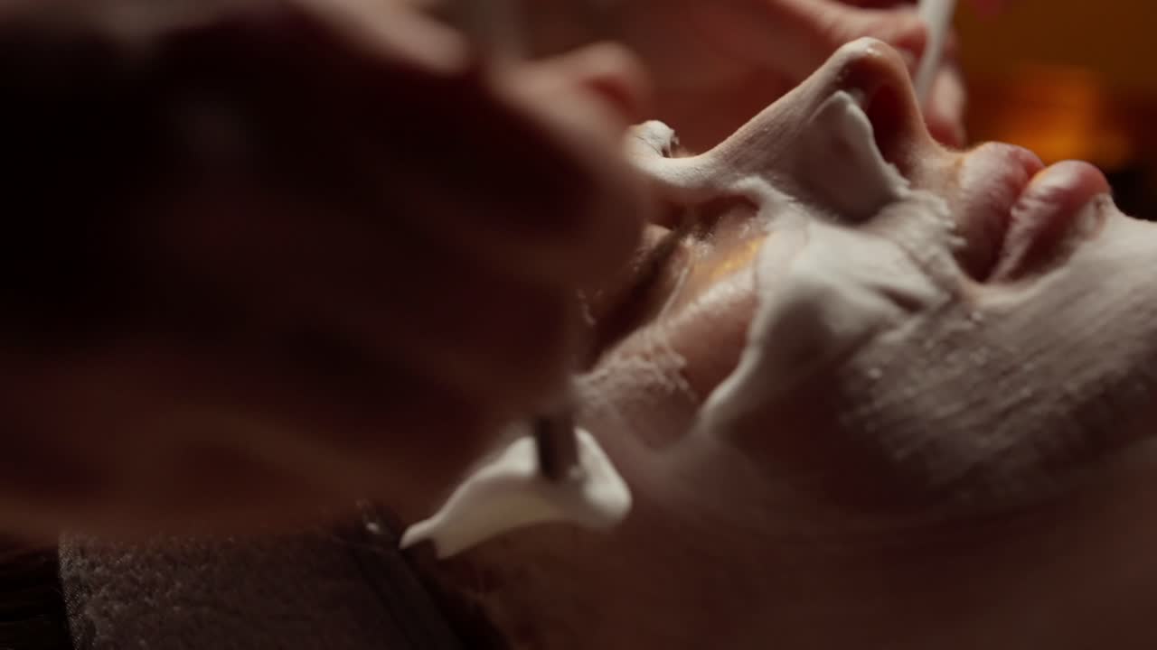 Donna che riceve l'applicazione di una maschera viso in una spa.