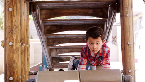 Young-Asian-boy-climbing-a-frame-in-school-playground