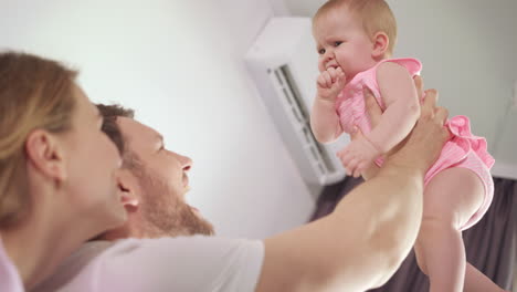 padre feliz sosteniendo al bebé en las manos. bebé alegre en el abrazo del padre