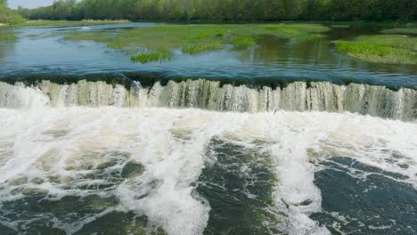 Aerial-establishing-view-of-Vimba-fish-,-Kuldiga,-sunny-spring-day,-slow-motion-drone-dolly-shot