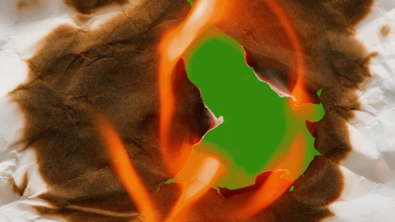 transición de video espectacular. una hoja arrugada de papel blanco coge fuego desde el centro hacia afuera. listo para su uso en el proyecto. fondo verde aislado