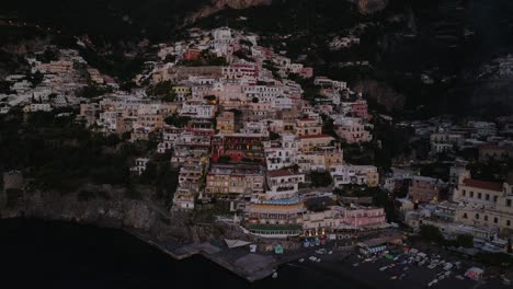 flying close to positano cliffside village in the mediterranean sea at sunset on amalfi coast, southern italy