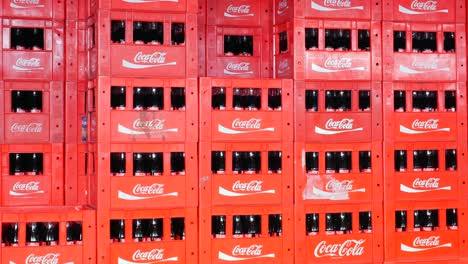 stack of red coca-cola crates filled with bottles