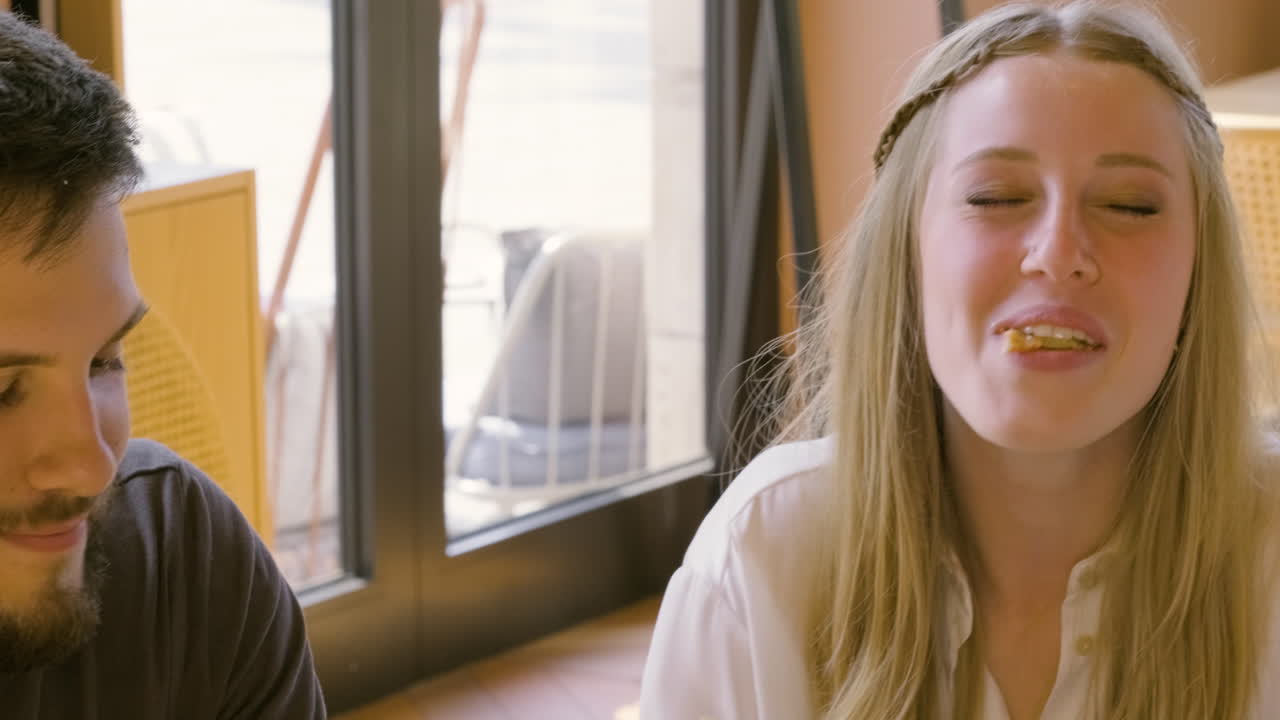 식당에서 여자친구에게 피자 한 조각을 먹이는 행복한 남자