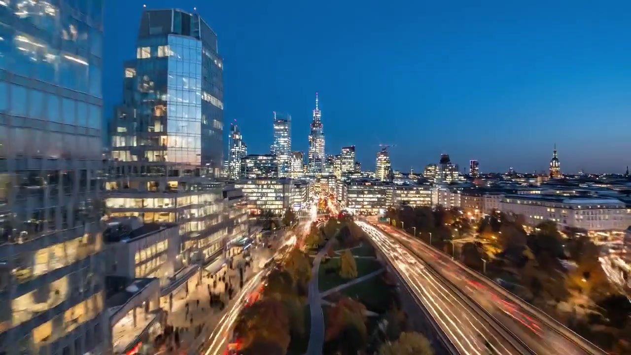 Dynamische urbane Nachtlandschaft, die eine belebte Stadtstraße mit lebhaftem Verkehr, modernen Wolkenkratzern und beleuchteter Infrastruktur vor einem Dämmerungshimmel zeigt