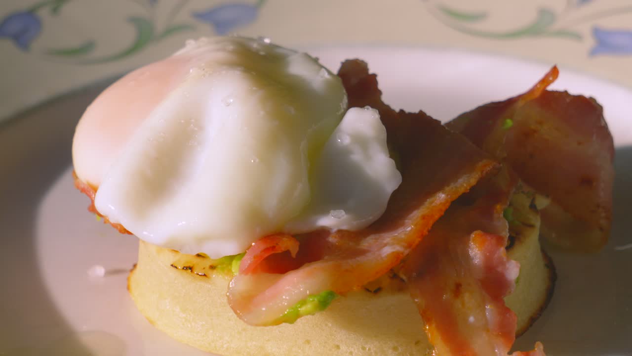 Pan Across Delicious Breakfast of Avocado Crumpet with Crispy Bacon Topped with Poached Egg. Morning High Protein Healthy Stylish Food Brunch Footage 4K.