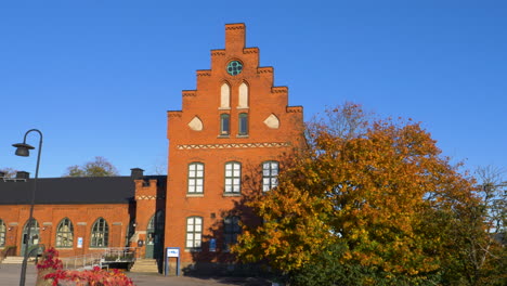 Exterior-Of-Kviberg-Military-Barracks-In-Gothenburg,-Sweden-With-Autumn-Foliage-In-Foreground-On-A-Sunny-Day