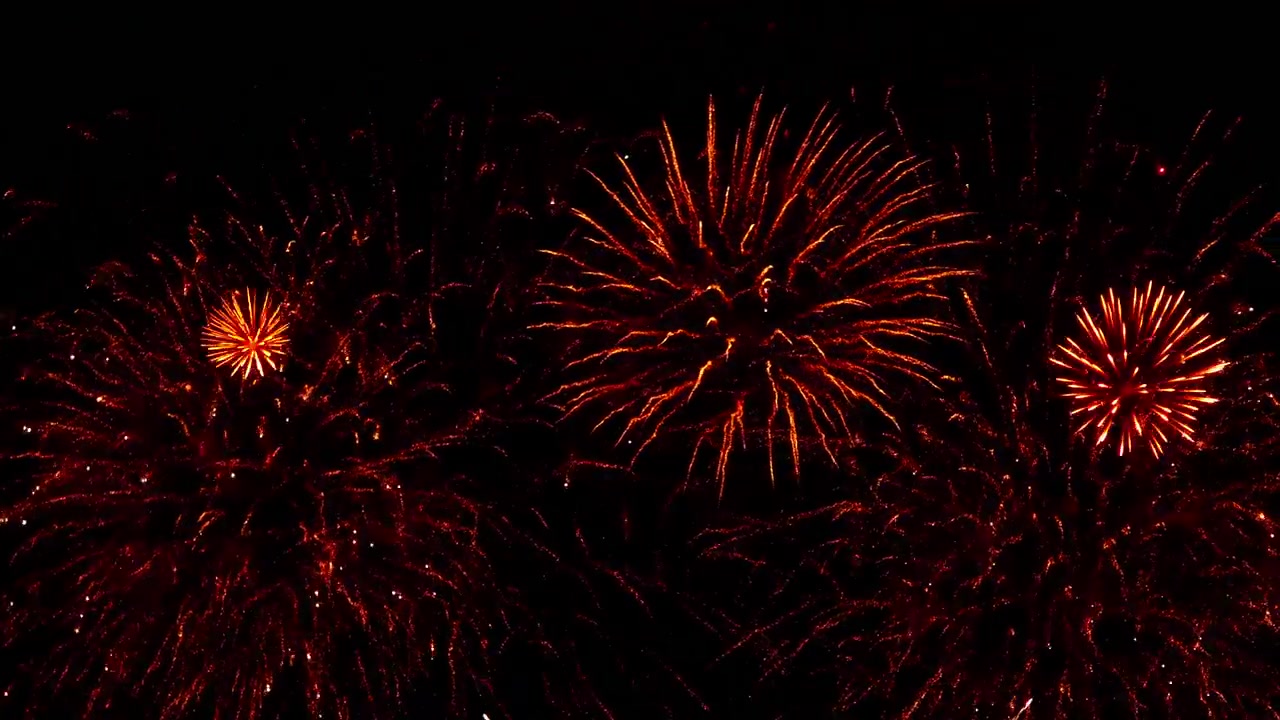 壯觀的煙花在漆黑的夜空中以絢麗的色彩綻放，營造出一個充滿閃爍軌跡和光芒的璀璨慶典場景