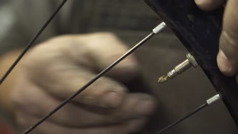 a bicycle mechanic adjusting the air valve of a bicycle inner tube