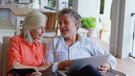 Senior-couple-discussing-over-laptop-on-sofa-4k