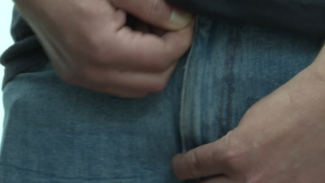 man fastening his jeans zipper