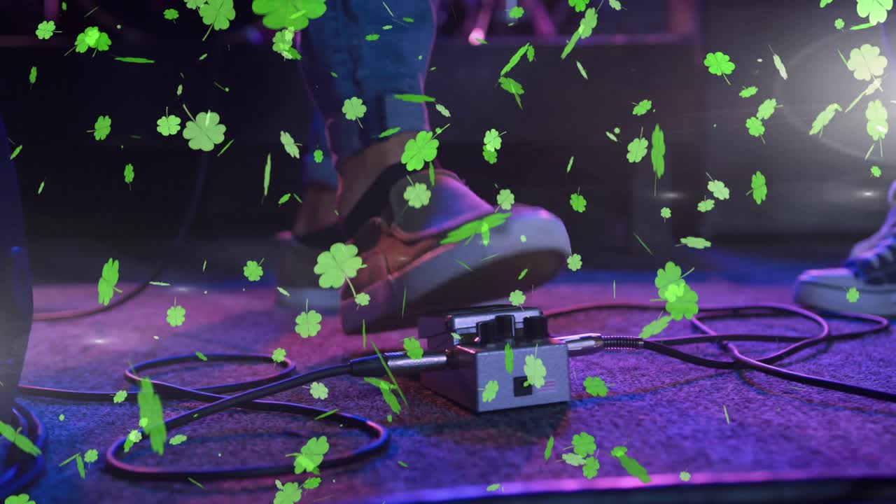 Animation of st patrick's day green shamrock falling over man playing on concert stage