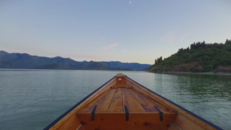 Un tranquillo giro in barca sul Lago di Scutari in Montenegro, circondato da montagne al tramonto