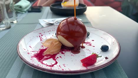 Lava-cake-with-caramel-that-melts-white-chocolate-sphere-served-in-an-restaurant-in-Iasi-Romania