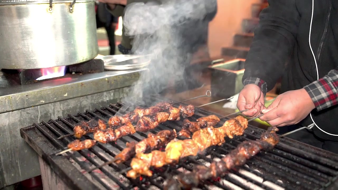 Personale che cucina barbecue alla griglia usando una macchina per barbecue per strada!