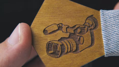 man holds wooden bow tie with carved camera picture macro