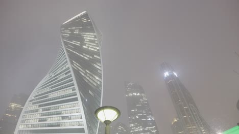 modern skyscrapers in a foggy night cityscape