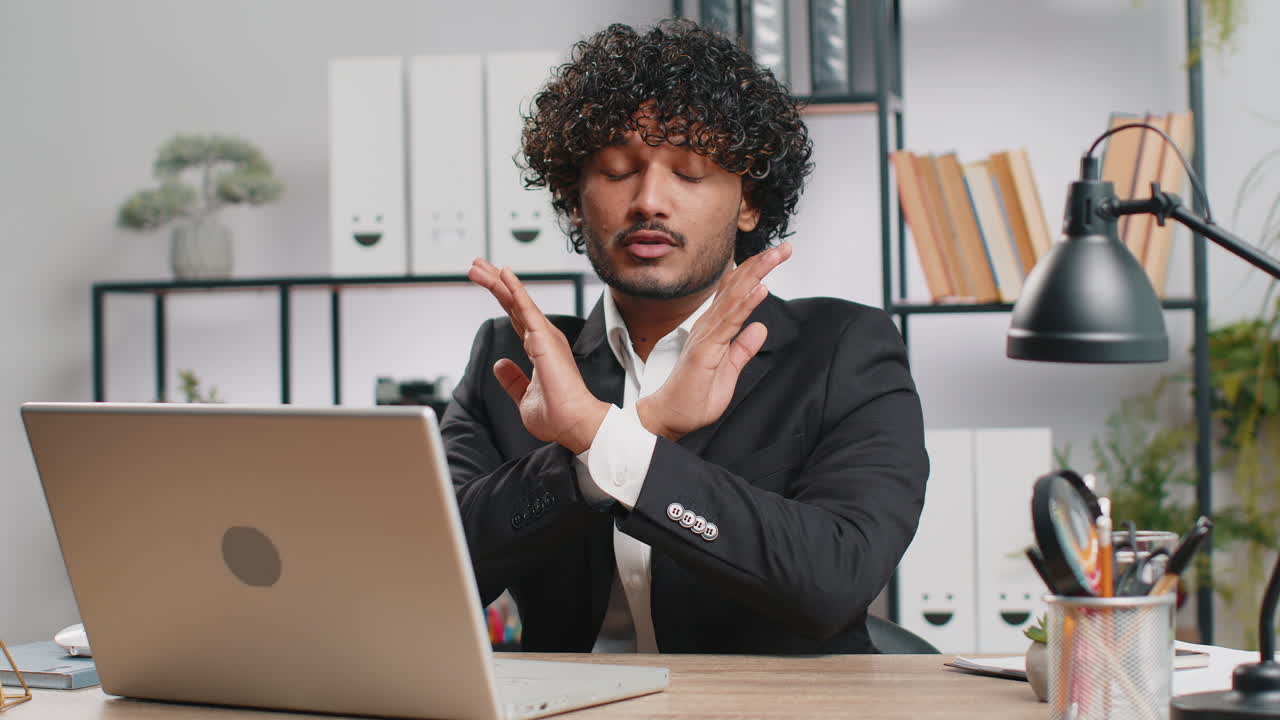 Businessman working on laptop showing stop gestuge danger rejection warning crisis prohibition