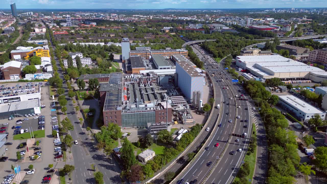 Aerial view of a city with highway, factory, and buildings