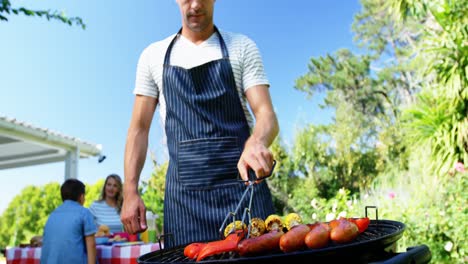 hombre volviendo pimienta de campana en la barbacoa