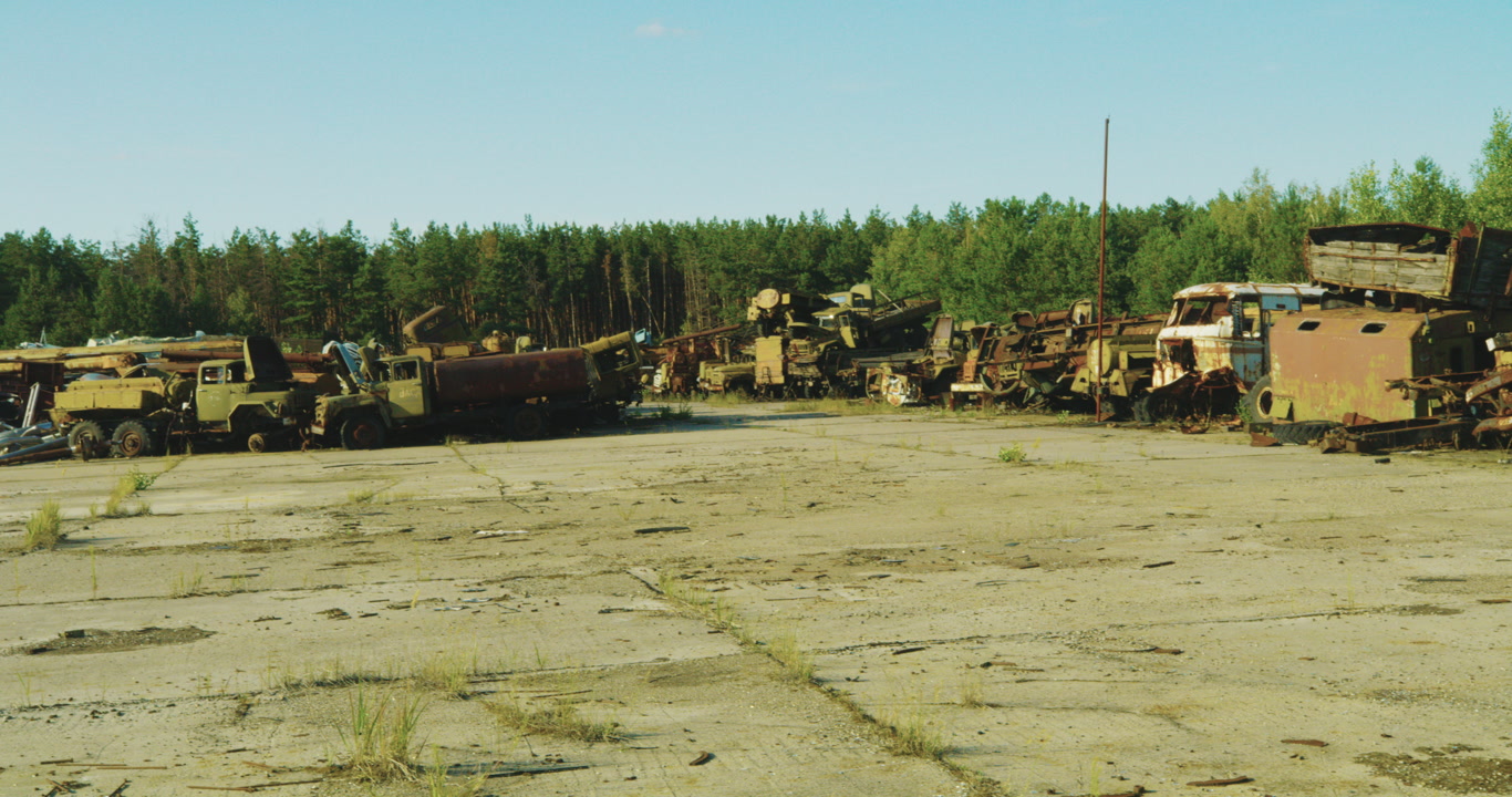 Wide shot of the Burikivka Radio Active Vehicle Graveyard in Chernobyl Exclusion zone, off limits.