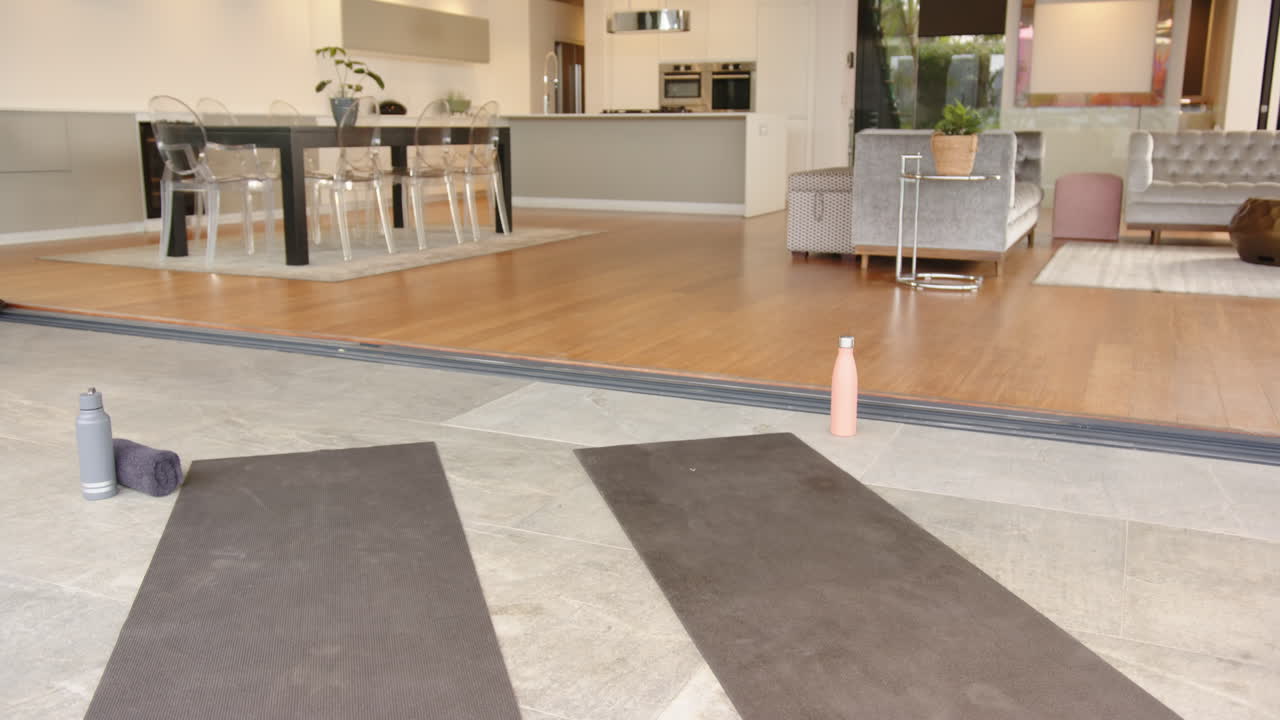 Yoga mats and water bottles set up for home workout in modern living room