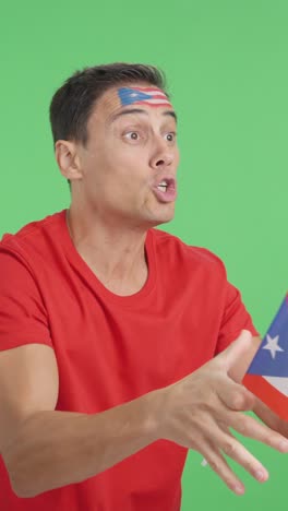 man cheering for puerto rico waving a national flag looking away