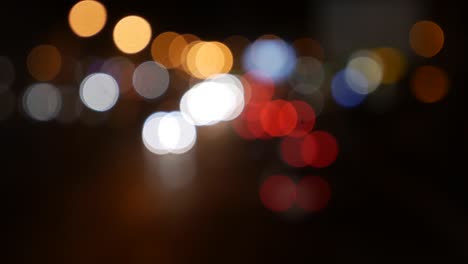 hermoso bokeh brillante en el fondo oscuro borroso por la noche. el redondo bokeh colorido brilla de las luces de los coches en la calle de la ciudad. fuera de foco con borroso. luces de la ciudad sin enfoque. bokeh de tráfico. concepto abstracto