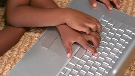 Siblings-using-laptop-on-the-floor