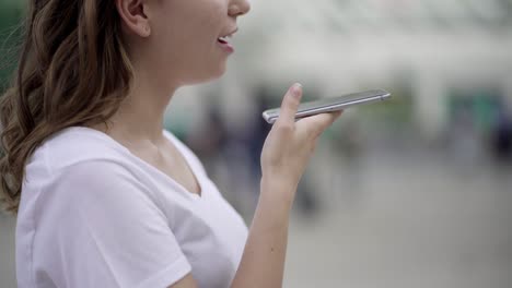 foto recortada de una mujer usando el reconocimiento de voz de un teléfono inteligente