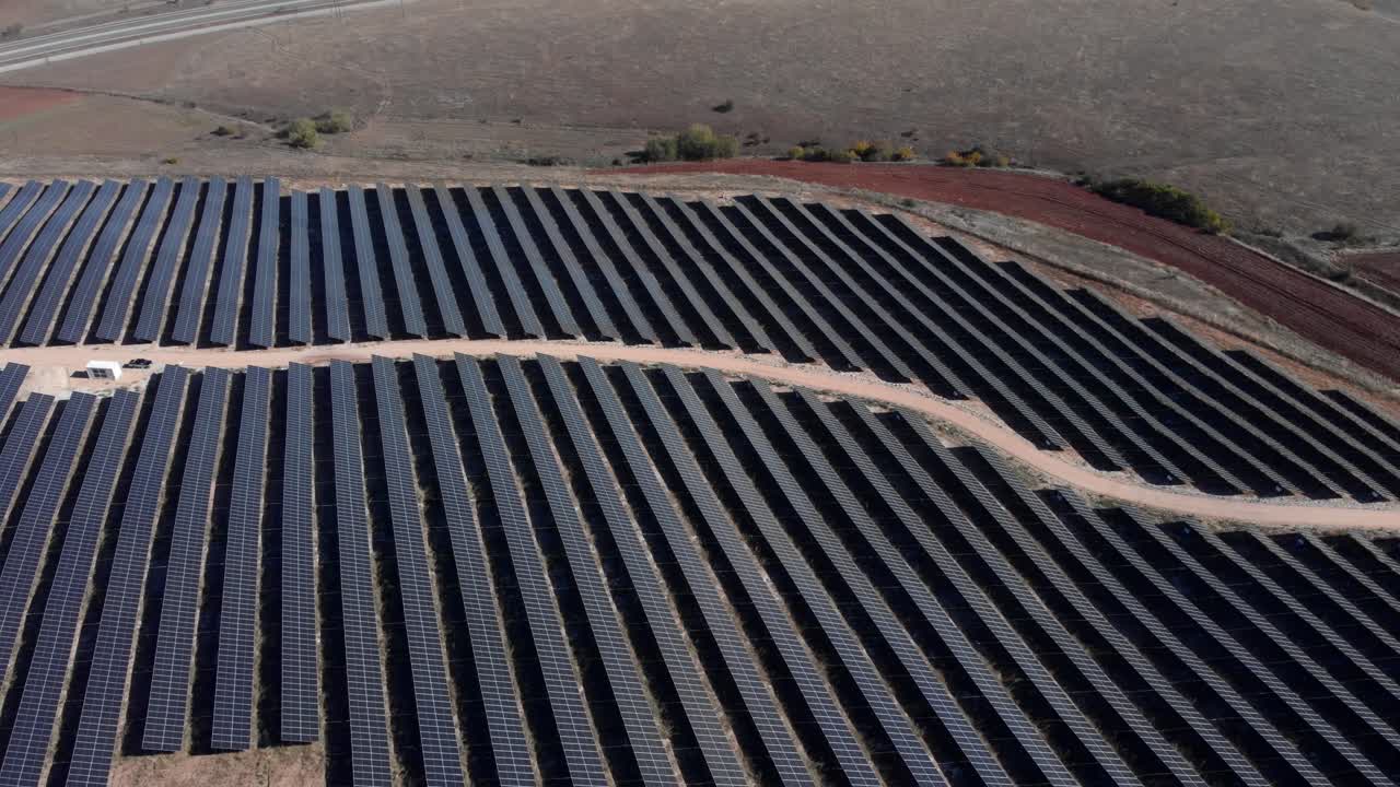 tilt down Drone over photovoltaic solar park farm row panels hills panning down