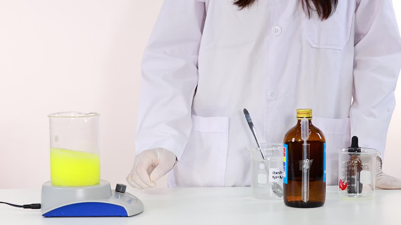 과학자는 실험실 장비 설정으로 요오드 시계 반응 실험을 보여줍니다.