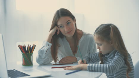 Young-Woman-Helps-Little-Girl-To-Do-Homework-Using-Laptop